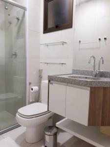 a bathroom with a toilet and a sink and a shower at VG Sun Cumbuco in Cumbuco
