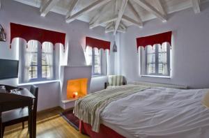 sypialnia z łóżkiem, biurkiem i oknami w obiekcie Ariston w mieście Papigko