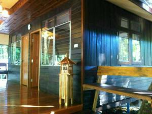 a house with a bench and a bird house on the porch at Koh Kood Little Hut in Ko Kood