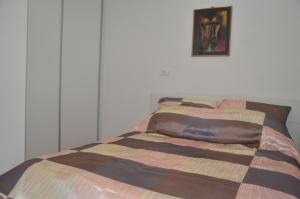a bed with a striped comforter in a bedroom at Sarajevo City Center in Sarajevo