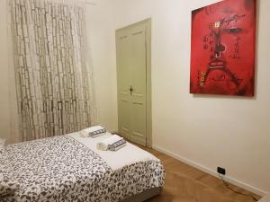 1 dormitorio con 1 cama y una pintura en la pared en GIURIA 35 - Elegante ed accogliente nei pressi del Valentino en Turín