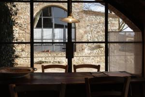 a dining room table and chairs in front of a window at The Lazy Olive Villa - Podere Finerri in Asciano