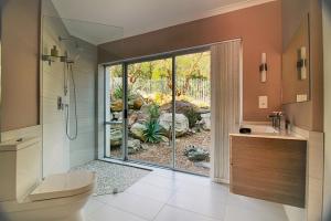 a bathroom with a shower and a toilet and a sink at Diamond House Guesthouse in Cape Town +37 photos