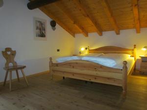sypialnia z drewnianym łóżkiem i stołem w obiekcie Casa Lausa w mieście Mazzin