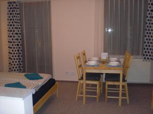 ヤーヒモフにあるApartmán pod Klínovcemのテーブル、椅子、ベッドが備わる客室です。