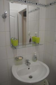 a white bathroom with a sink and a mirror at Apartmán pod Klínovcem in Jáchymov