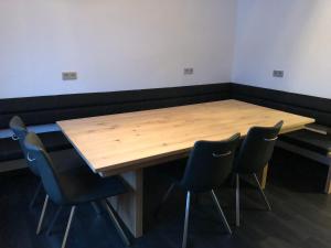 a conference room with a wooden table and four chairs at FeWo Bettenhausen in Morschen