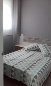 テルエルにあるApartamento Ebroのベッド(チェック入りの毛布付)