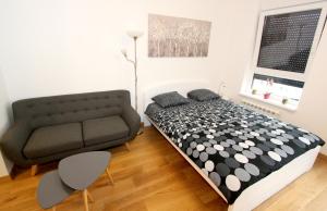 a small bedroom with a bed and a couch at Apartment Moonstone in Belgrade