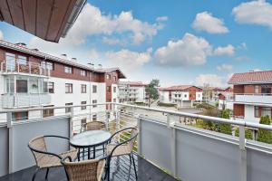 a balcony with a table and chairs on a building at Grand Apartments - Neptun Park. in Gdańsk