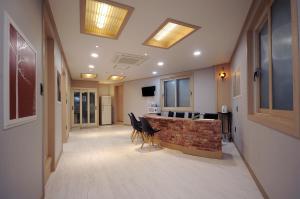a hallway with chairs and a fireplace in a building at Family Hotel BNB in Busan