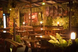 a restaurant with wooden tables and chairs and lights at Ruanmai Style Resort 2 in Ban Nong Nam Khan