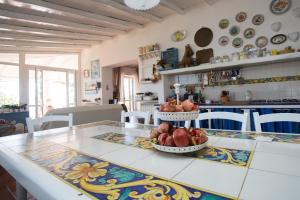 a kitchen with a table with two baskets of fruit on it at Rosa Dei Venti in Lipari +43 photos