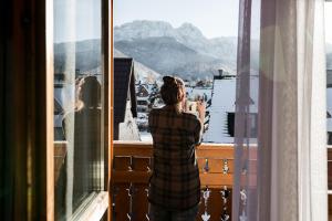 a woman taking a picture of a view from a window at Willa Malinowa in Zakopane