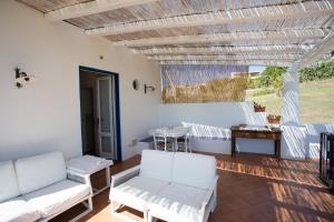a patio with white chairs and a table at Rosa Dei Venti in Lipari