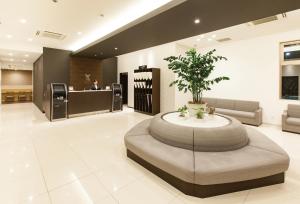 um lobby com uma mesa com uma planta nele em Y's HOTEL Shin Osaka em Osaka