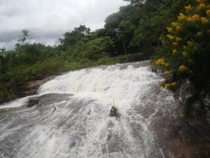 a waterfall in the middle of a river at SUITE - CIDADE das CACHOEIRAS in Santa Rita de Jacutinga