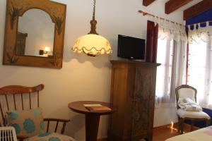 a room with a tv and a table and a mirror at Posada Real La Mula de los Arribes in Villardiegua de la Ribera