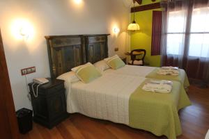 a bedroom with a large bed with two towels on it at Posada Real La Mula de los Arribes in Villardiegua de la Ribera