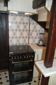 een keuken met een zwarte oven in de kamer bij Maison au coeur d'Argelès in Argelès-Gazost