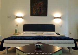 a bed in a room with two lights on the wall at Hotel Centre Point in Jodhpur +12 photos
