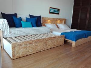 a bedroom with two beds and a couch at Beach & Relax - Studio in Costa da Caparica +36 photos