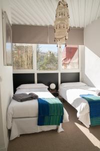 - une chambre avec 2 lits et une grande fenêtre dans l'établissement Fabuloso Apartamento En Sierra Nevada, à Sierra Nevada