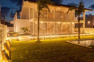 a large house with palm trees in front of it at Vilamaré Gostoso in São Miguel do Gostoso