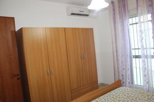 トッレ・スーダにあるVilletta/Appartamento Mahia1のベッドの横に木製キャビネットが備わるベッドルーム1室が備わります。