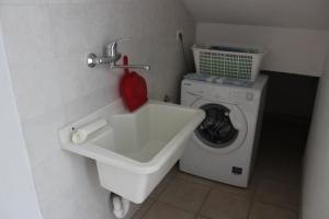 トッレ・スーダにあるVilletta/Appartamento Mahia1のバスルーム(シンク、洗濯機付)
