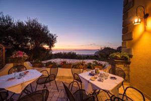 two tables and chairs on a patio with a sunset at Agriturismo Antico Casale Colli Di San Pietro in Piano di Sorrento