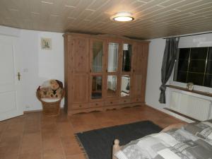 een woonkamer met een houten kast en een bed bij Weineck in Nejdek