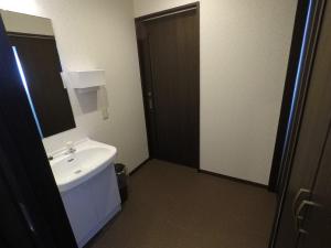 a bathroom with a white sink and a mirror at Pension Berg in Kutchan