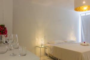 a bedroom with a bed and two tables with wine glasses at Vilamaré in São Miguel do Gostoso