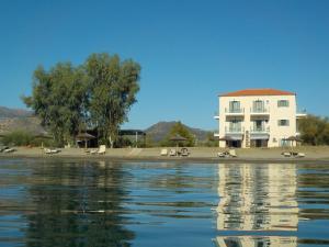 a building on a beach next to a body of water at Akti Kamares in Kamáres