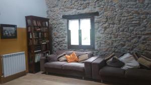 a living room with a couch and a stone wall at Otardi in Asteasu