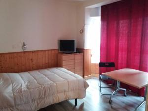 a bedroom with a bed and a table and a television at Rosesapparts Estudios & Parking in Roses