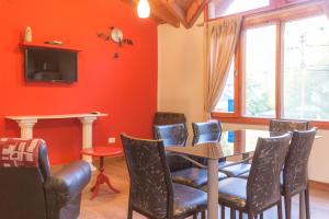 comedor con paredes de color naranja, mesa y sillas en El Solito en Villa La Angostura
