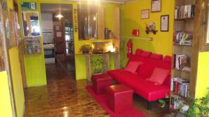 a living room with a red couch and yellow walls at Hostal y Cabañas Mozart in Puerto Montt