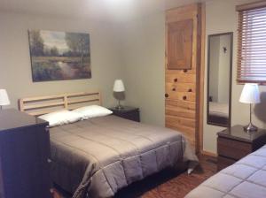a bedroom with a bed and two lamps and a window at Madawaska Lodge in Madawaska