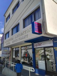 un uomo in piedi fuori da un edificio di Hotel Antartida Argentina a Ushuaia