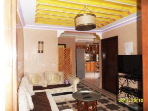 a living room with a couch and a tv at Appartement Terrasse Beau Soleil in Essaouira