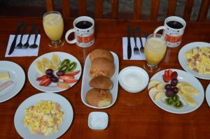 a table with plates of breakfast food and drinks at Bosque Protector Hacienda Guamag in Baños