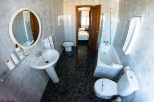 a bathroom with a sink and a toilet and a mirror at Hostal Caminito del Rey in Alora +33 photos