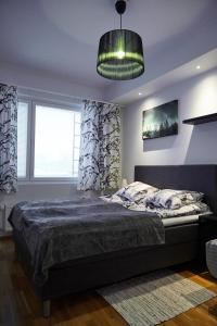 1 dormitorio con 1 cama y luz colgante en Arctic Oasis Apartments, en Rovaniemi