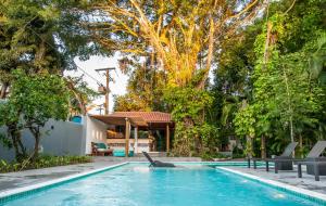 a swimming pool in a yard with trees at Pousada e Chalés Aquarius in Arraial d'Ajuda