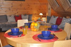 drewniany stół z talerzami i miskami z jedzeniem w obiekcie Apartament 33.13.a. w Zakopanem