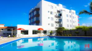 a hotel with a swimming pool in front of a building at Ingleses Park Hotel in Florianópolis