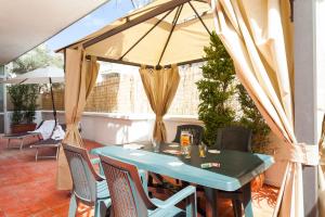 a blue table with chairs and an umbrella on a patio at Sorrento Central Flats in Sorrento