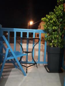 Una silla azul sentada en un balcón por la noche en Angelos Rooms, en Iraklia